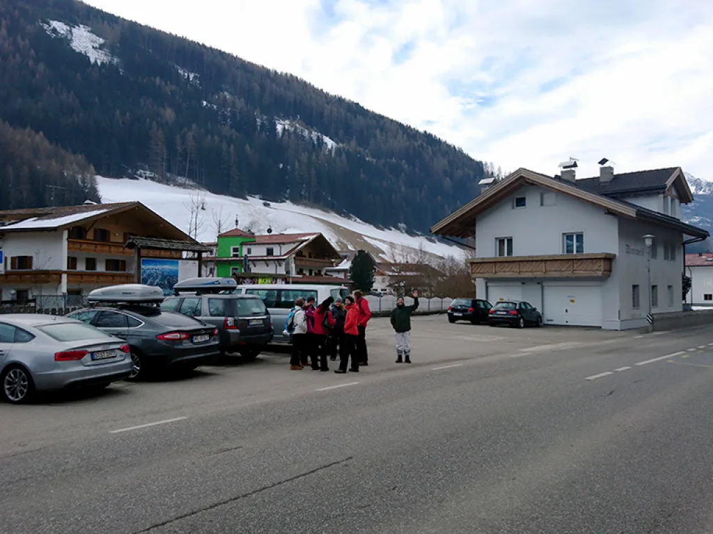 Blick über die Straße auf die Gruppe vor den Häusern des Orts.